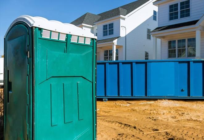 a row of portable toilets at a busy construction site